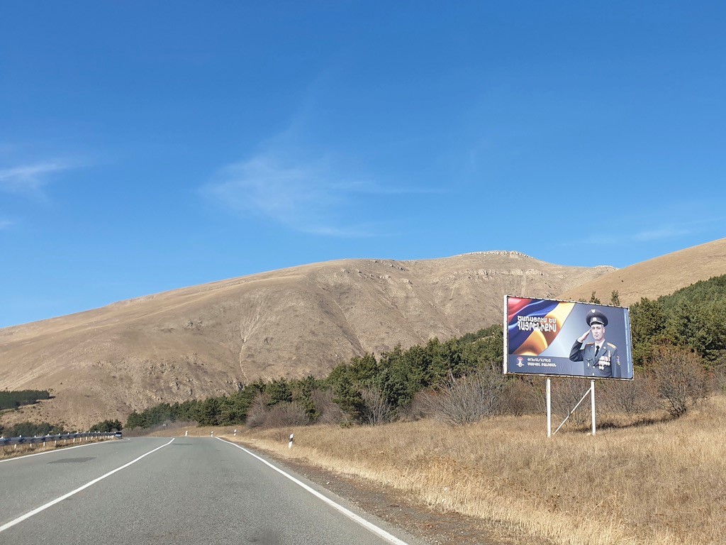 road in Armenia, caucasus with a military poster